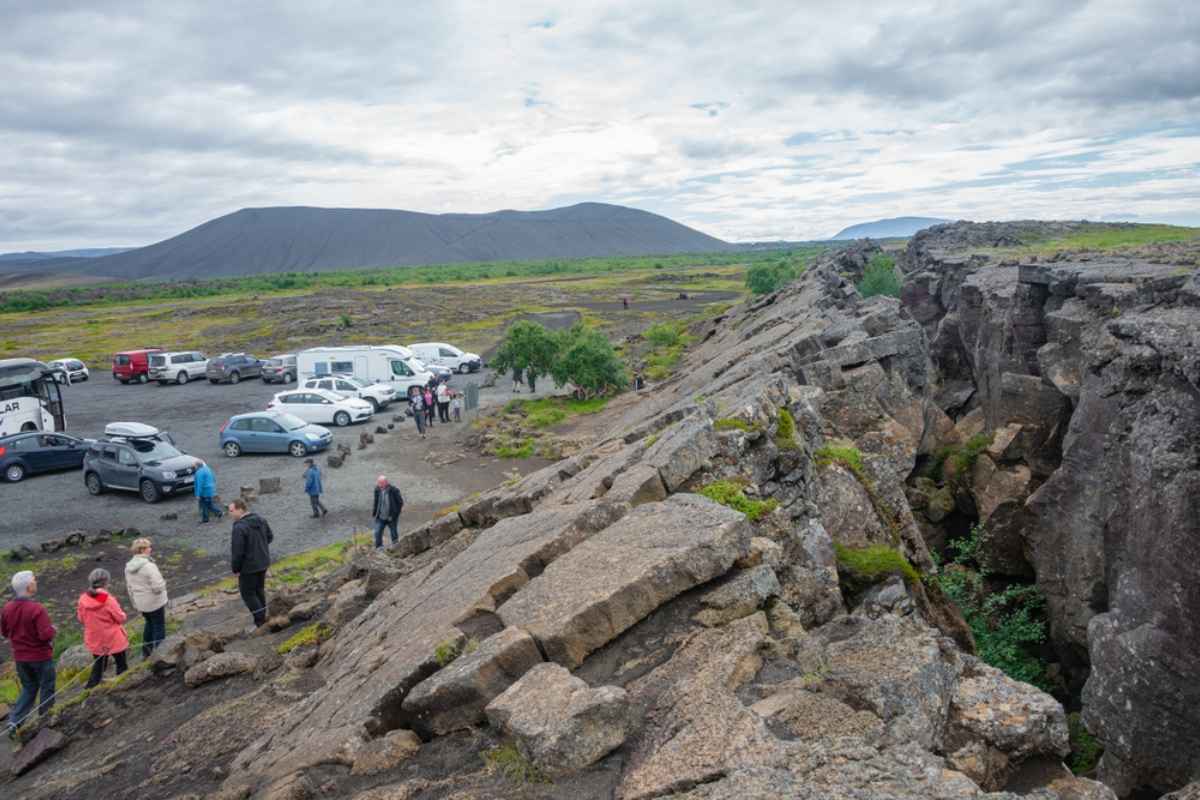 Parking lot with visitors right by the grjótagjá lava cave Group of tourist by the parking lot of the grjótagjá lava cave