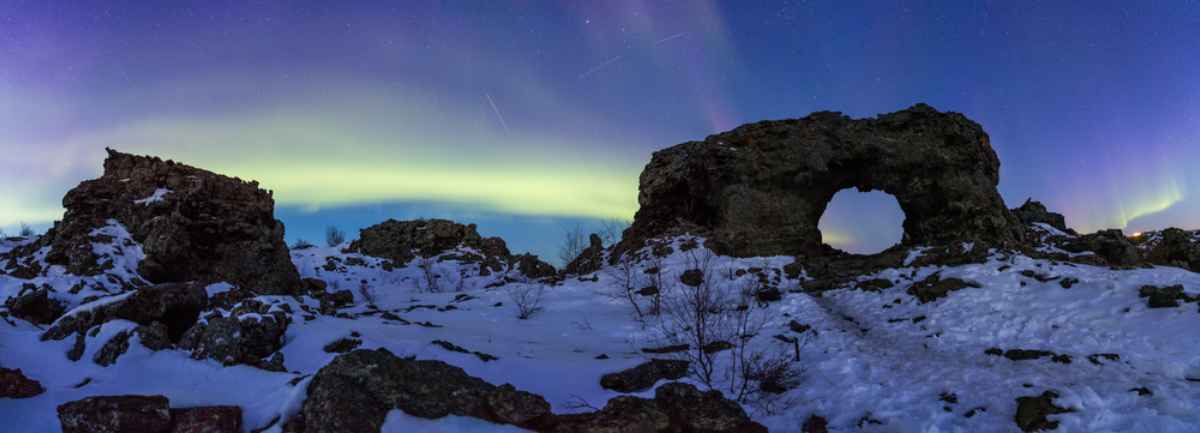 Green northern lights on top of a snow covered Dimmurborgir Northern lights dancing over Dimmurborgir, North Iceland