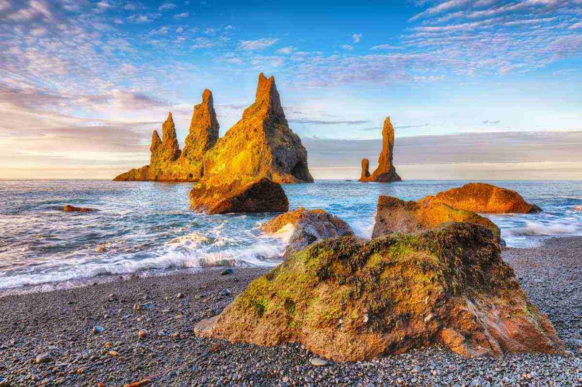 The last rays of sunlight illuminate the huge boulders jutting out from the shore of Iceland's South Coast.