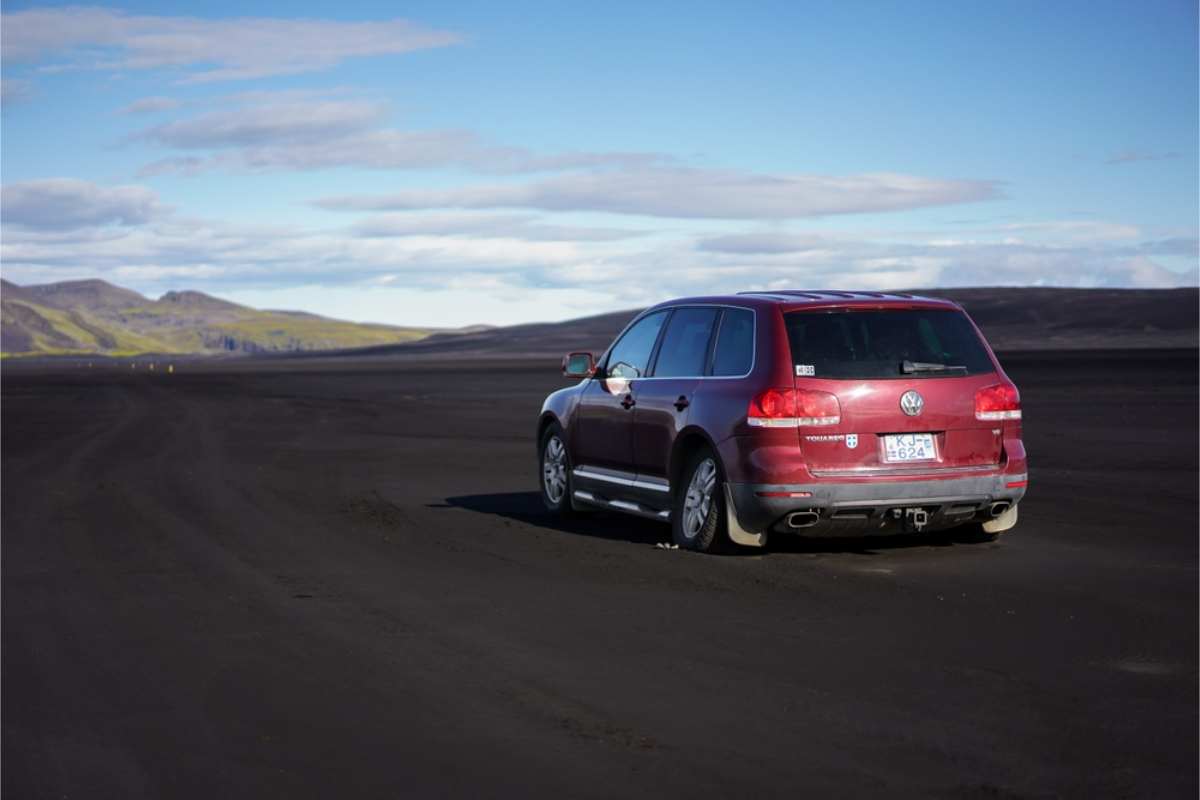Red 2WD car with a flat tire for driving in the wrong type of road