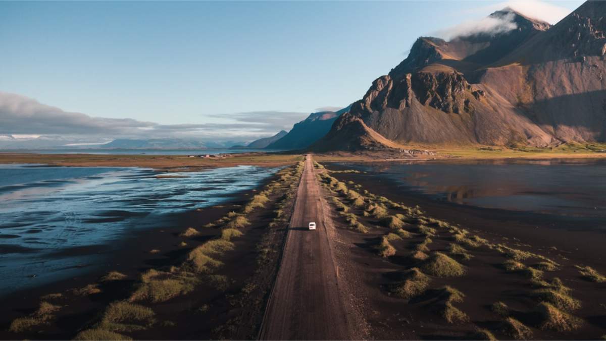 How to Choose the Right Vehicle for Your Trip Beautiful panoramic view of a car in the middle of an scenic route with Vestrahorn on the right