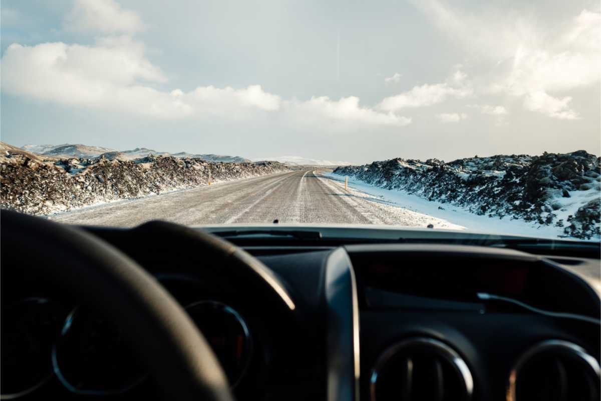 view of a snow covered road from the driver's side
