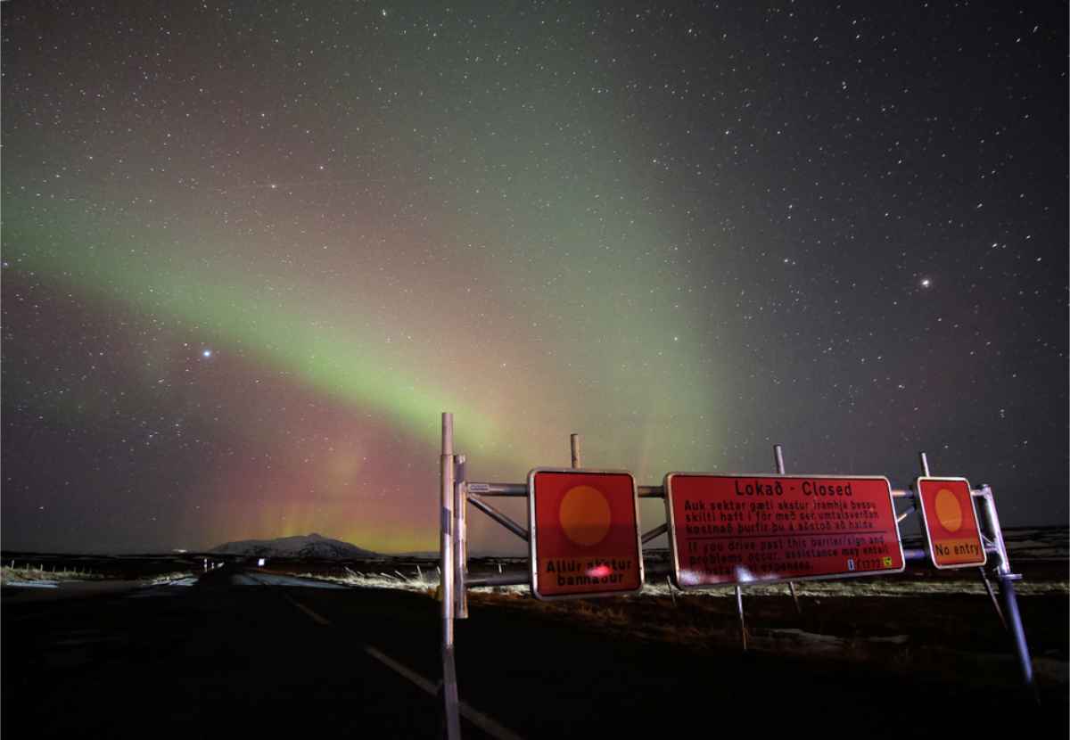 Carretera cerrada en Islandia con auroras boreales danzando encima