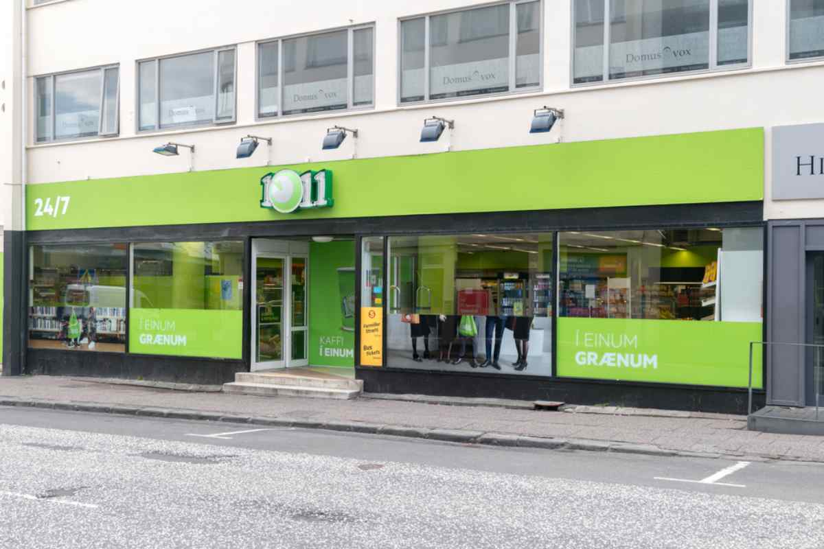 Exterior of a 10/11 convenience store in Iceland, open 24/7 with bright green signage.
