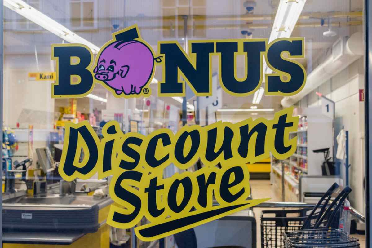 Window view of a Bónus discount supermarket in Iceland, featuring the pink pig logo and store interior.