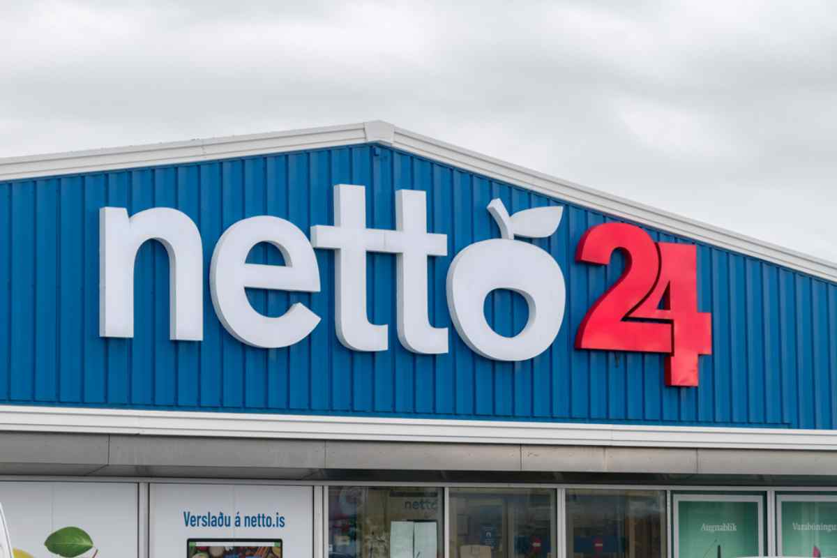 Entrance of a Netto 24 supermarket in Iceland with blue facade and large store logo.