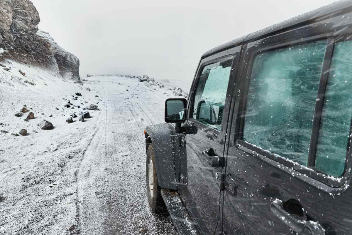 Driving a 4x4 while driving in Iceland in winter Black 4x4 driving on a snow-covered road in Iceland during wintry weather