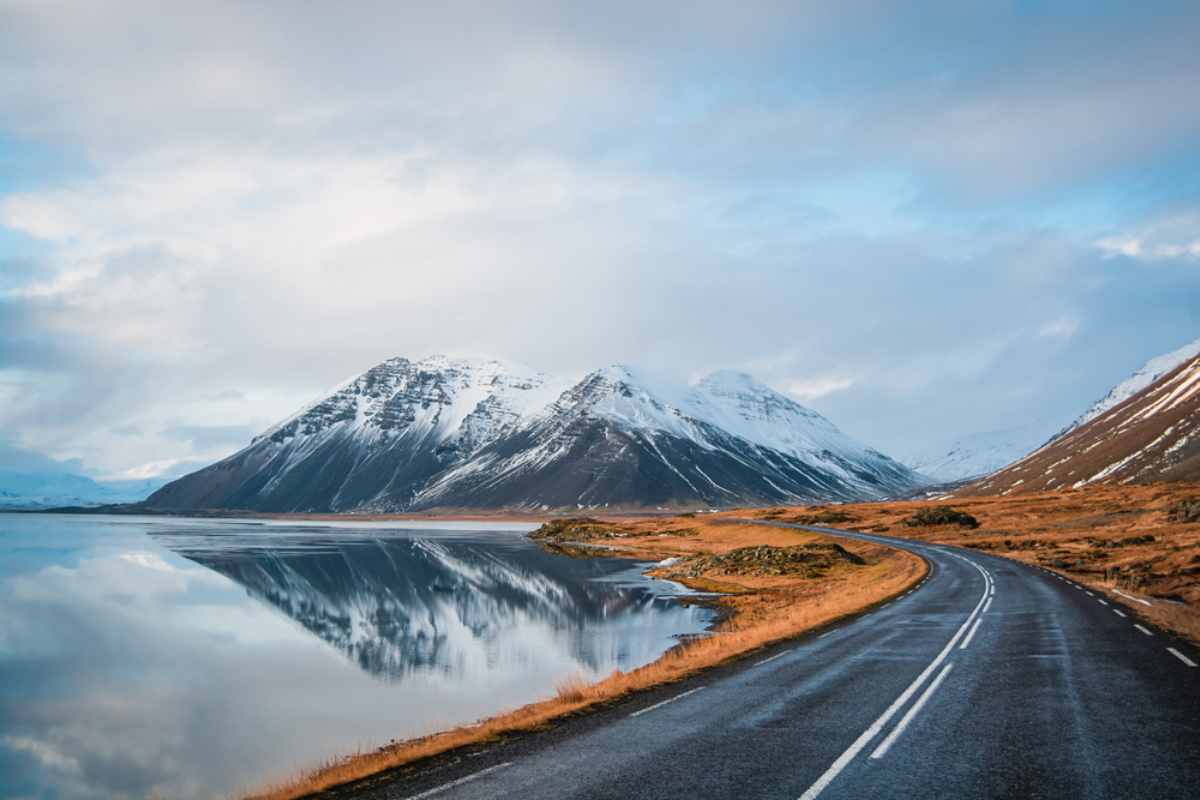 Alquilar un coche en Islandia: conduciendo por la Ring Road Tramo de la Ring Road en Islandia con montañas nevadas al fondo