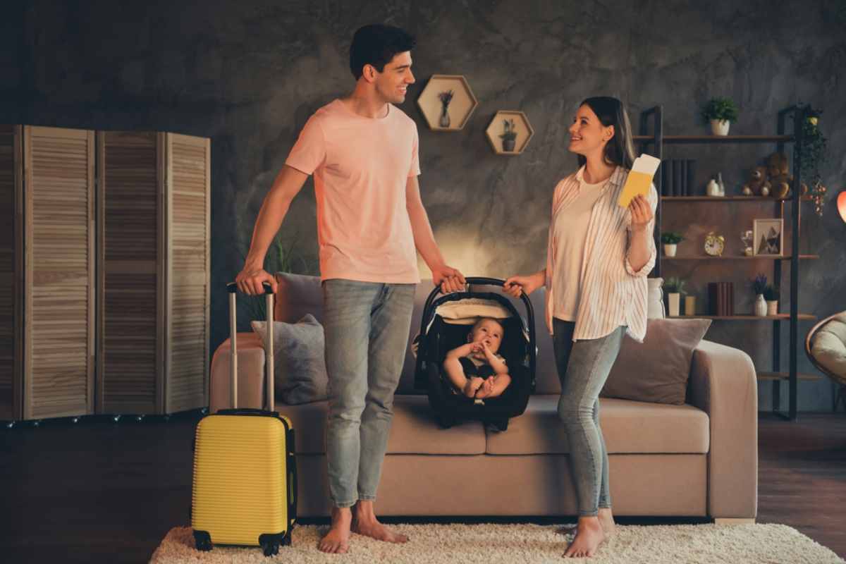 Padres con su beb&eacute; en una silla de coche port&aacute;til listos para viajar