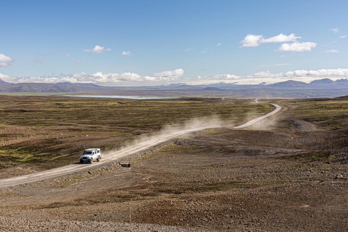 Minimiser le risque de dommages causés par le sable et les cendres en conduisant Jeep blanche roulant sur une route poussiéreuse et couverte de cendres