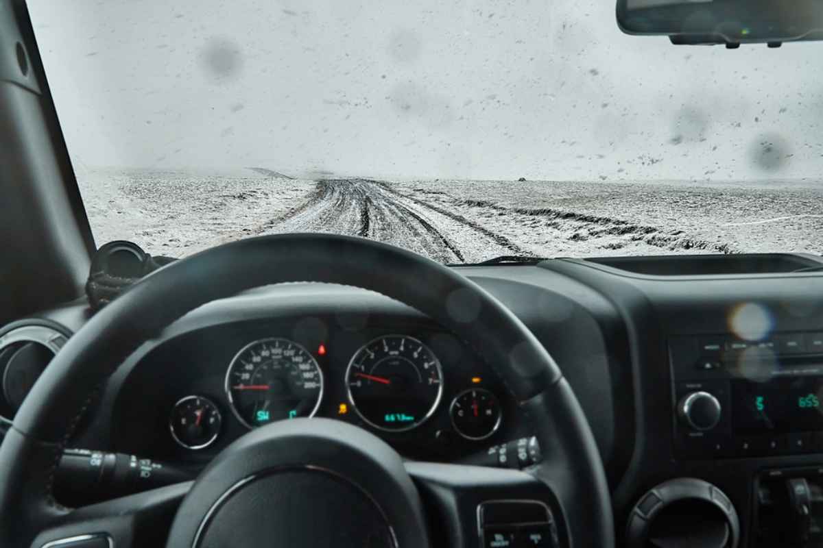 Consejos para conducir en invierno para turistas Vista de una carretera cubierta de nieve desde el lado del conductor