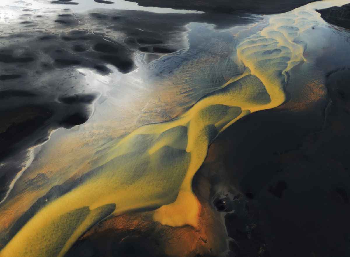 Was ist der Gelbe Fluss in Island? Luftaufnahme von geflochtenen, gelblichen Gletscherflüssen