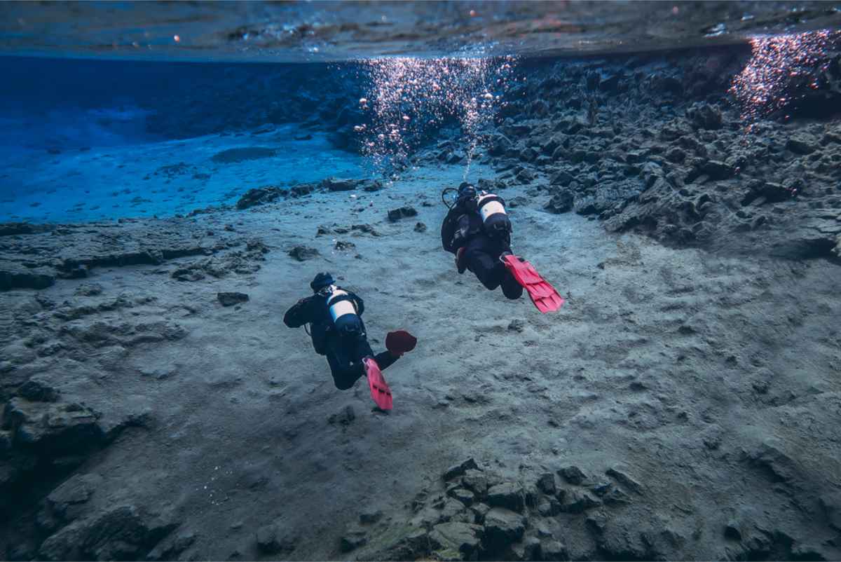 Buceadores nadando en la fisura Silfra en el Parque Nacional &THORN;ingvellir