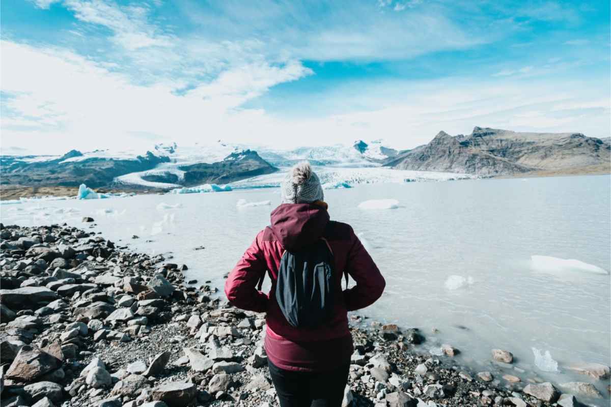 Alleinreisende Frau an der Jökulsarlon-Gletscherlagune