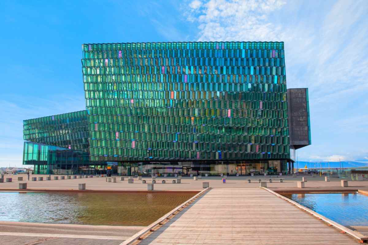 Harpa Concert Hall in Reykjavík mit Glasfassade, die den Himmel spiegelt.