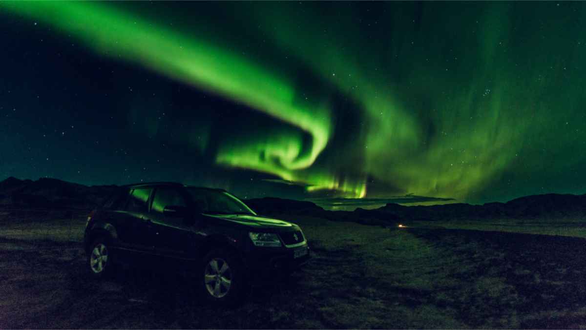 4x4 car parked right under the Northern Lights