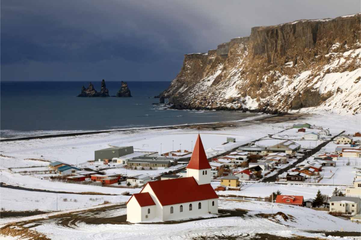 Best places to visit in Iceland in January Panoramic view of the village of Vik, South Iceland, covered in snow.