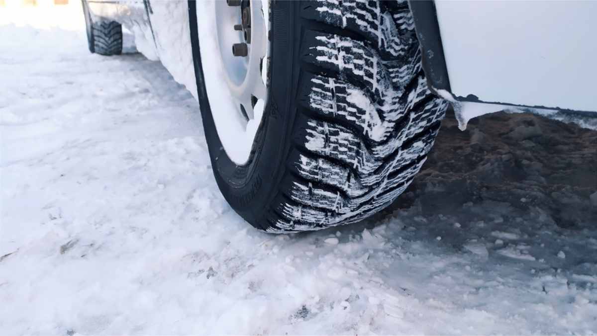 Driving in Iceland in winter Close up of a winter tire for rental cars