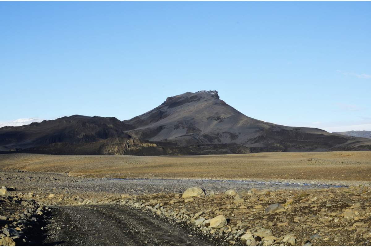 Gravel F-road crossing a barren highland landscape in Iceland during summer