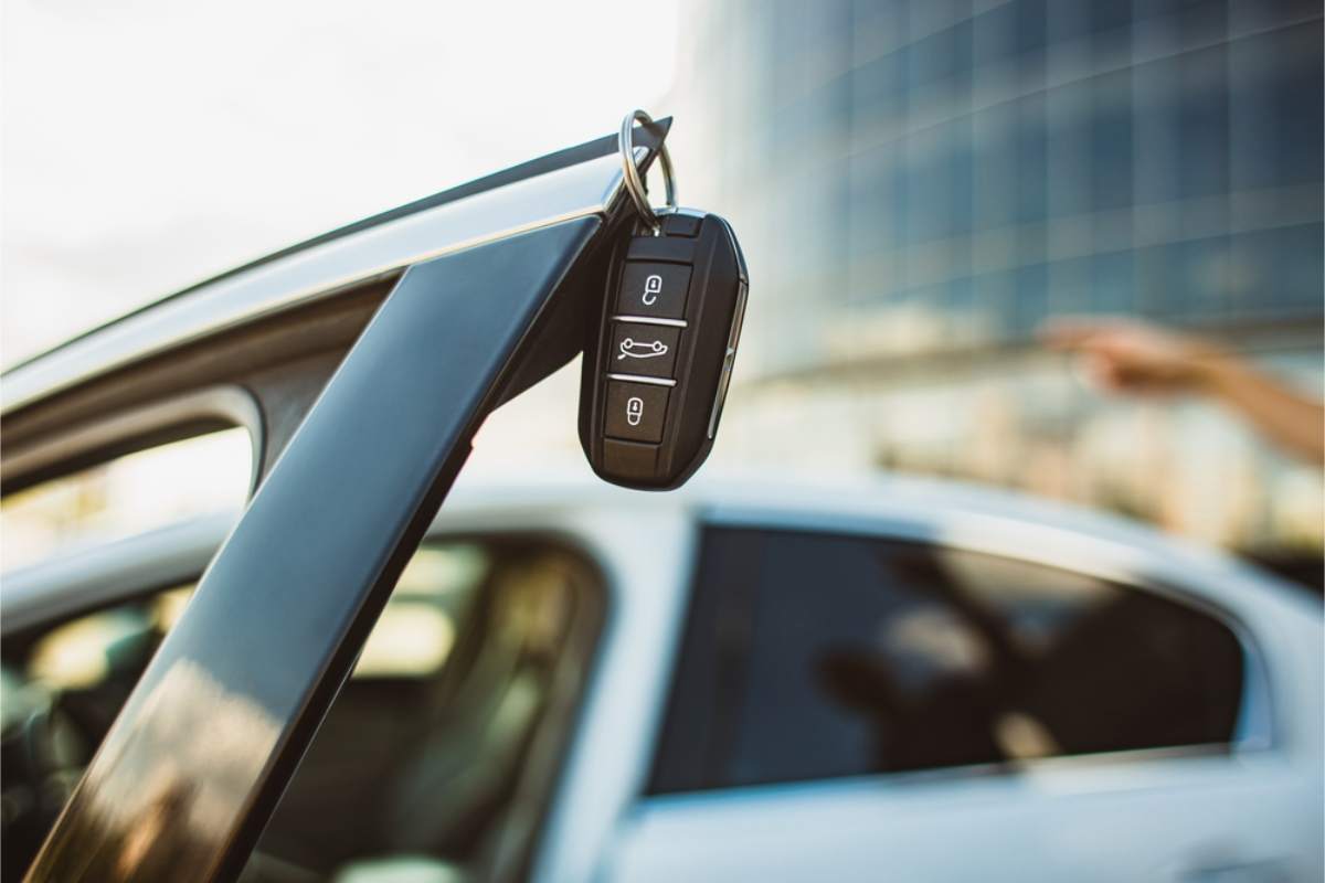 Car key hanging from an open vehicle door, illustrating rental car pickup in Iceland
