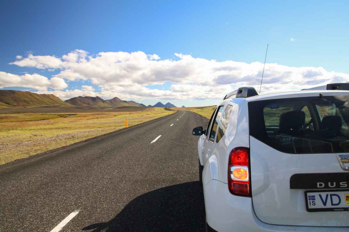 Driving a 2WD in Iceland Small car parked on the side of the Ring Road in Iceland under a bright blue sky