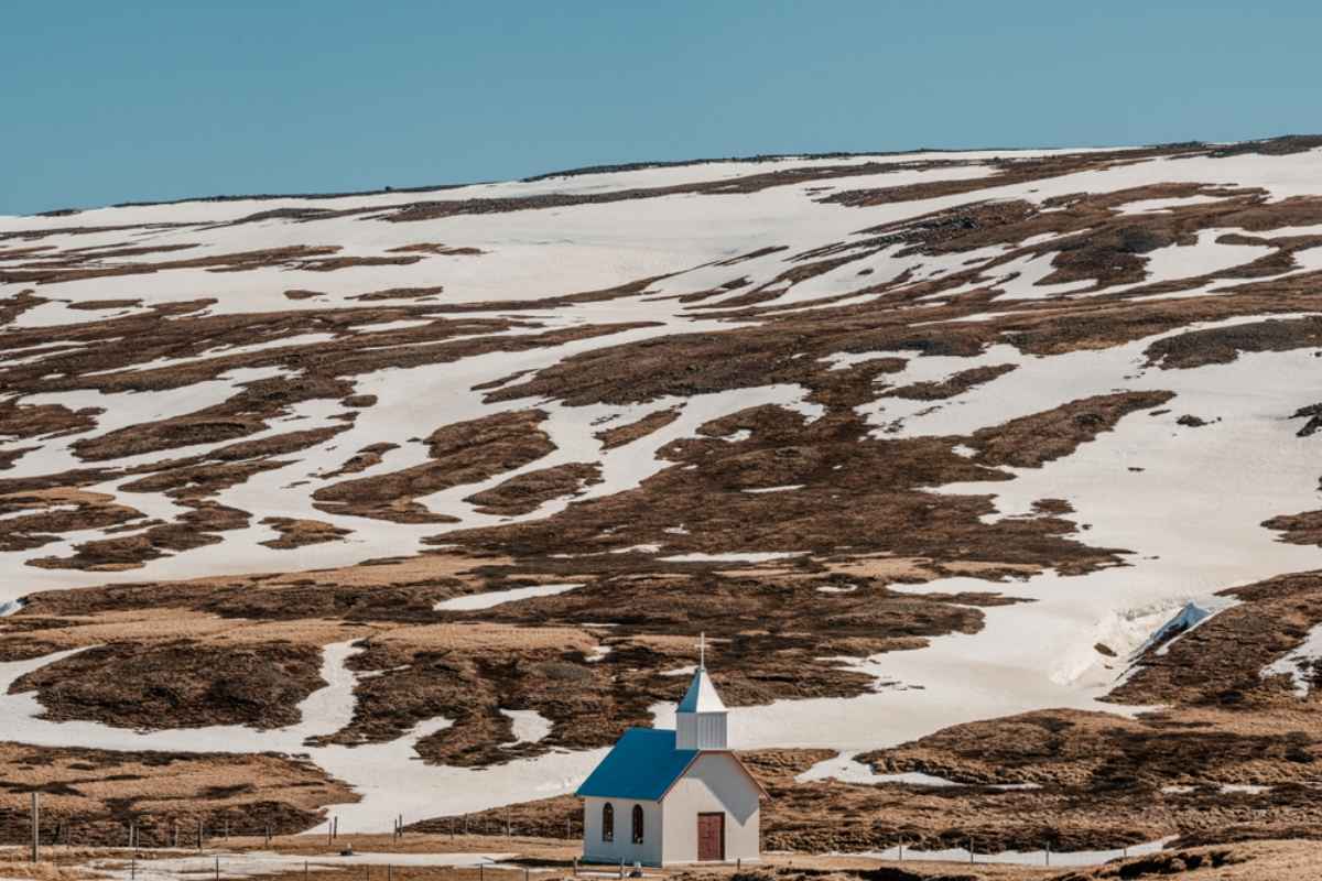 Iceland's Eastfjords Small church with a blue roof set against snowy hills in the Eastfjords of Iceland