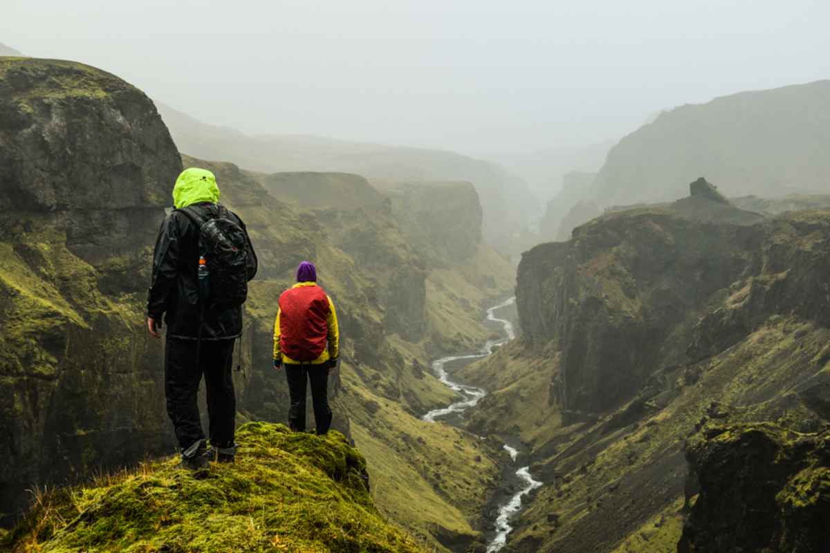 Iceland's Þórsmörk Two hikers standing on a cliff above a winding river canyon in Þórsmörk, Iceland