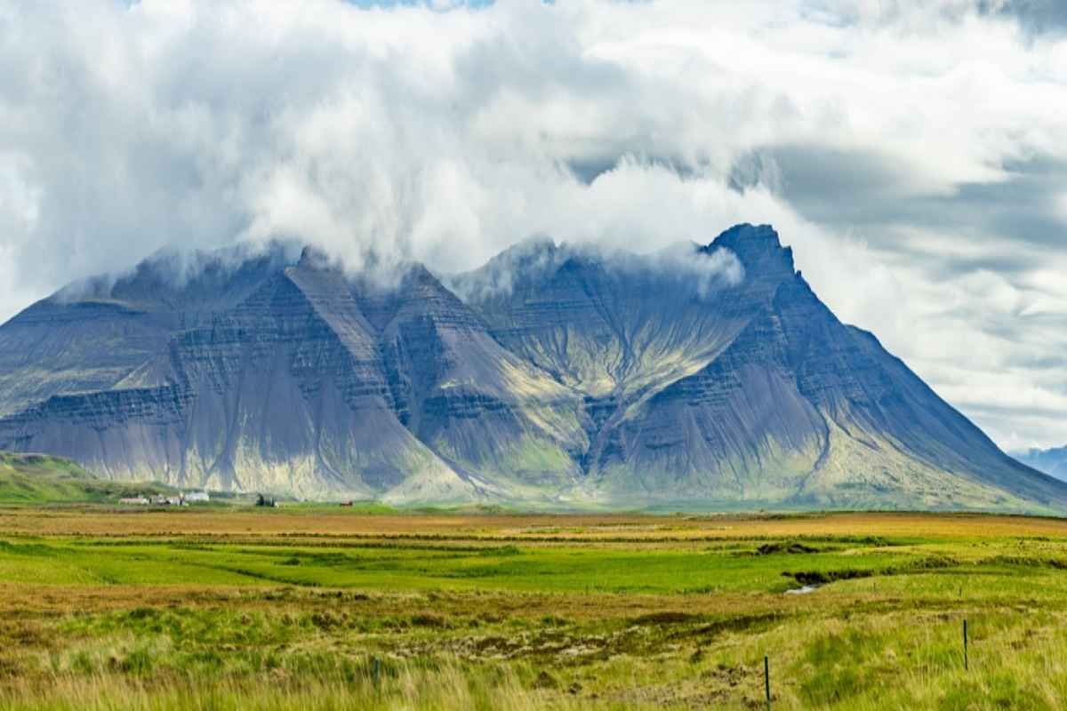 Iceland's Snæfellsnes Clouds hanging over a dramatic mountain and green fields on the Snæfellsnes Peninsula in Iceland