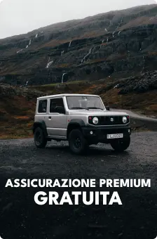 SUV Suzuki Jimny argento parcheggiato su una strada di montagna in Islanda, che evidenzia l’assicurazione premium gratuita inclusa nei noleggi di Cars Iceland.