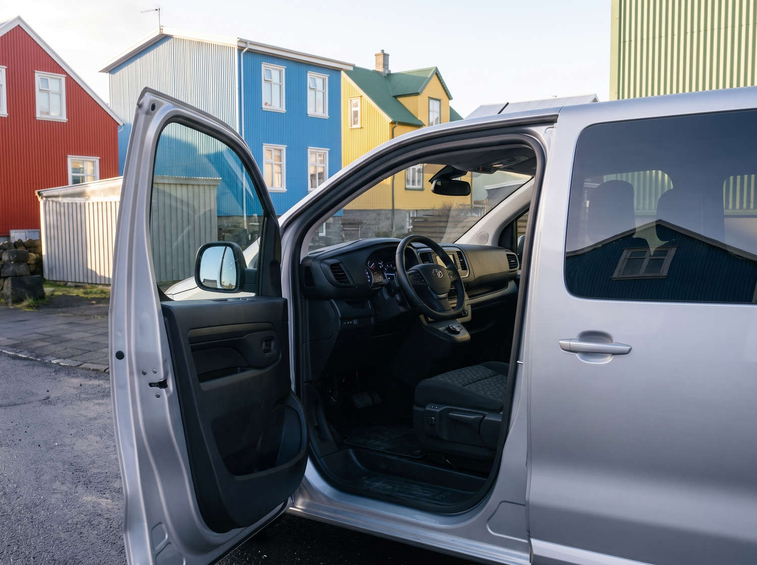 Silver Toyota Proace 9-seater van with automatic transmission, GPS, Bluetooth, heated seats, and USB charger for group travel in Iceland.