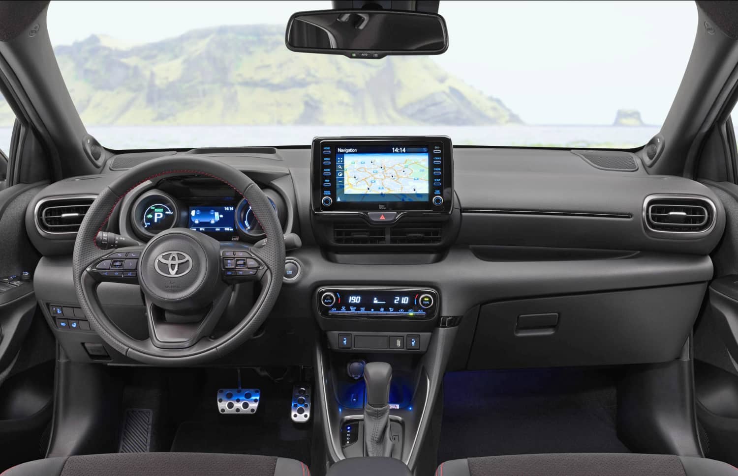Toyota Yaris hybride rouge avec boîte automatique, 5 places, GPS, caméra de recul et capacité pour 2 bagages, idéale pour voyager en Islande.