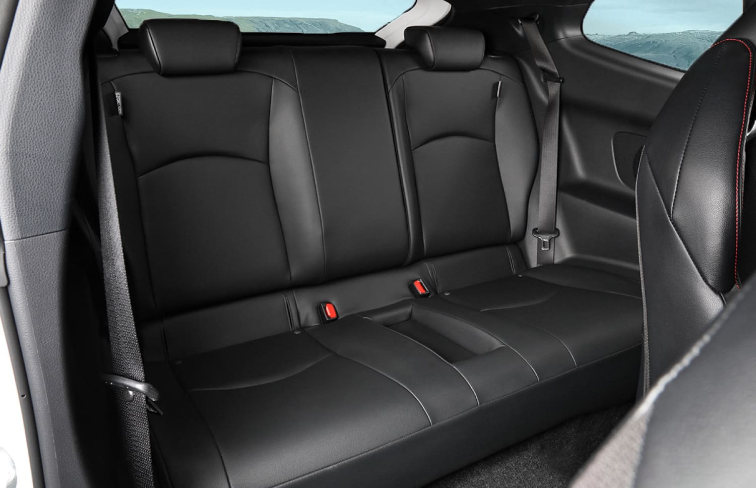 Toyota Yaris hybride rouge avec boîte automatique, 5 places, GPS, caméra de recul et capacité pour 2 bagages, idéale pour voyager en Islande.