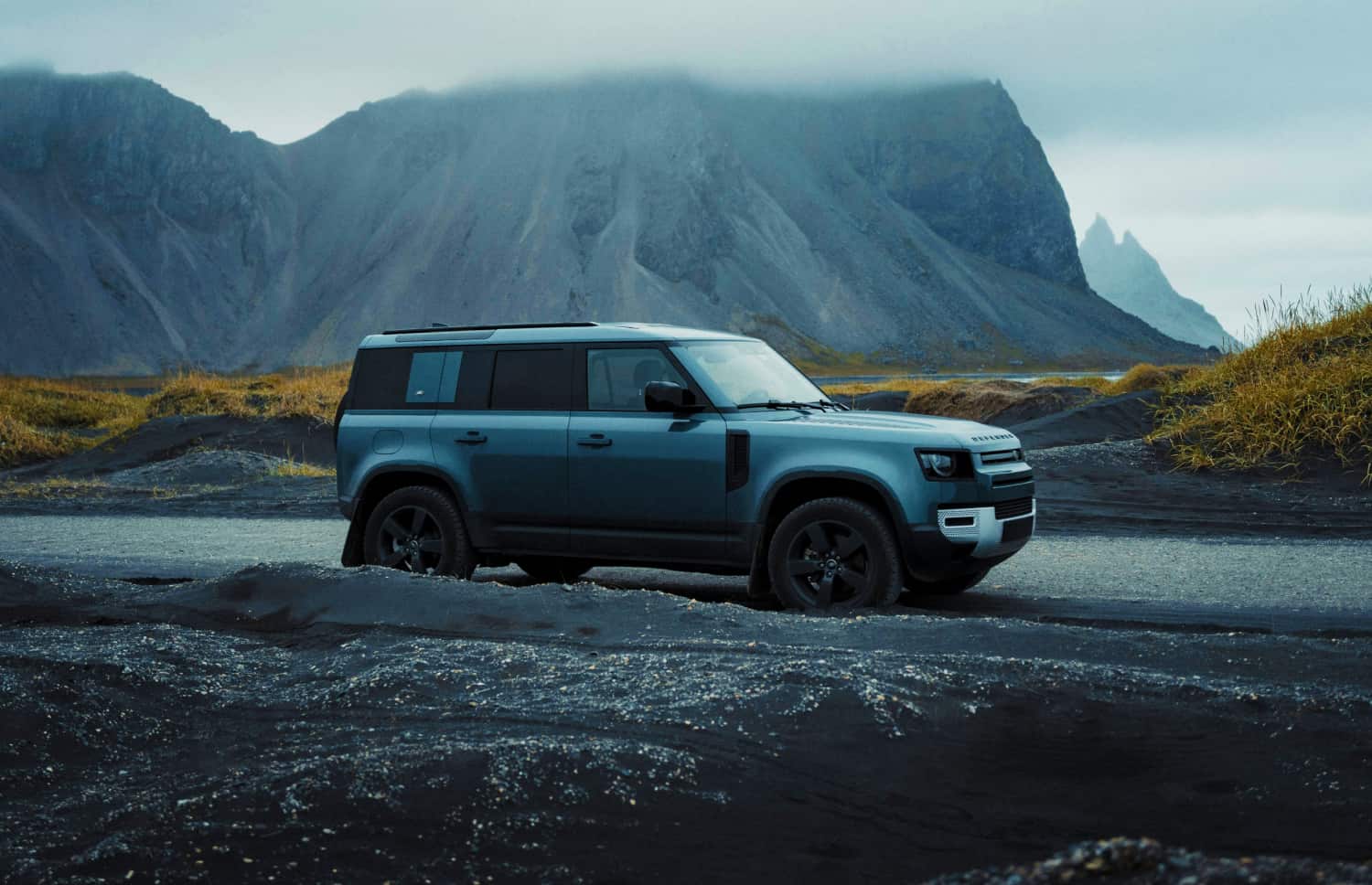 Land Rover Defender gris, SUV 4x4 de luxe avec GPS, sièges chauffants, chargeur USB et caméra de recul, parfait pour les routes accidentées d’Islande.