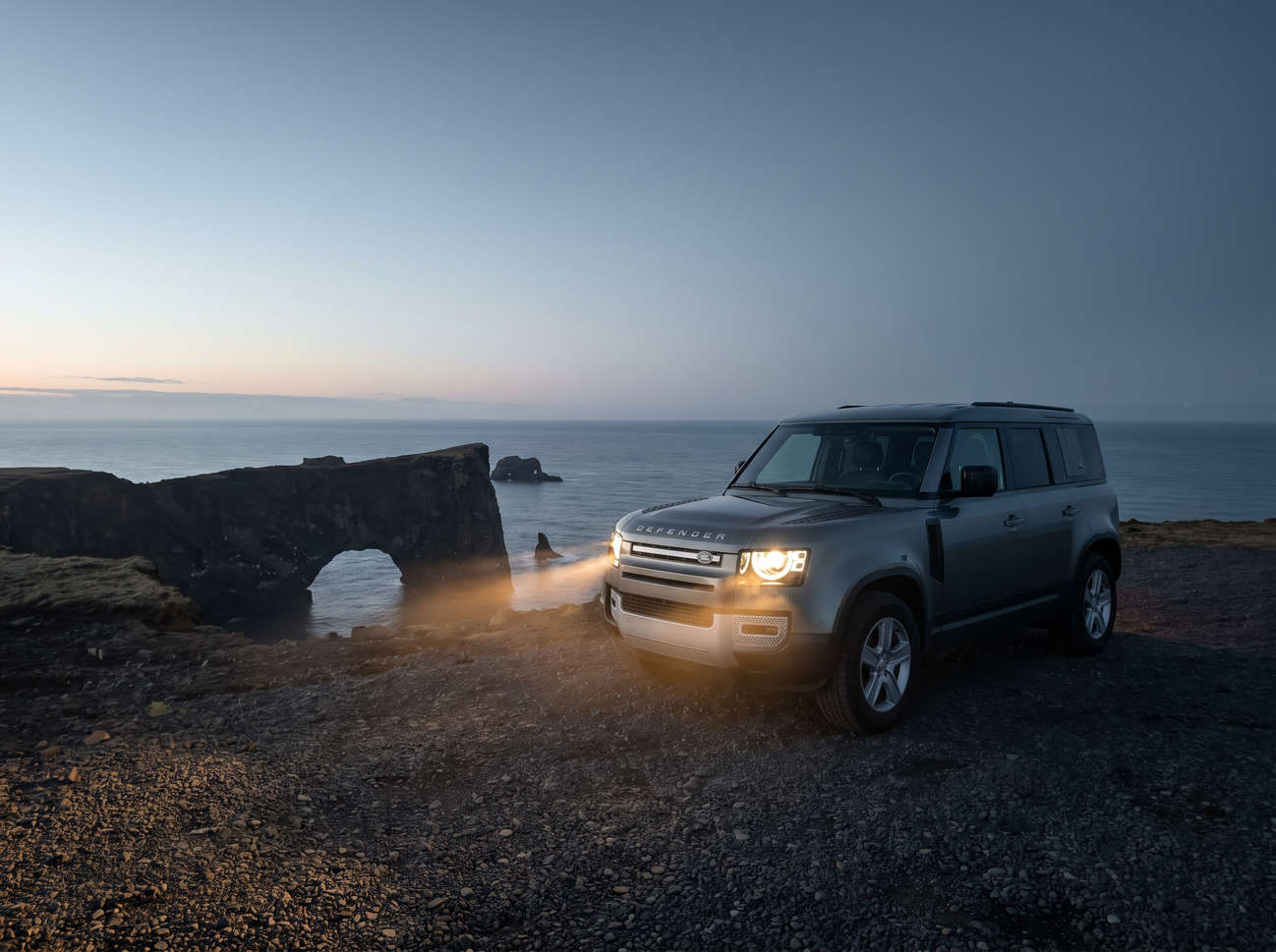 Land Rover Defender luxury 4WD SUV in gray with GPS, heated seats, USB charger, and reverse camera for rugged Iceland travel.