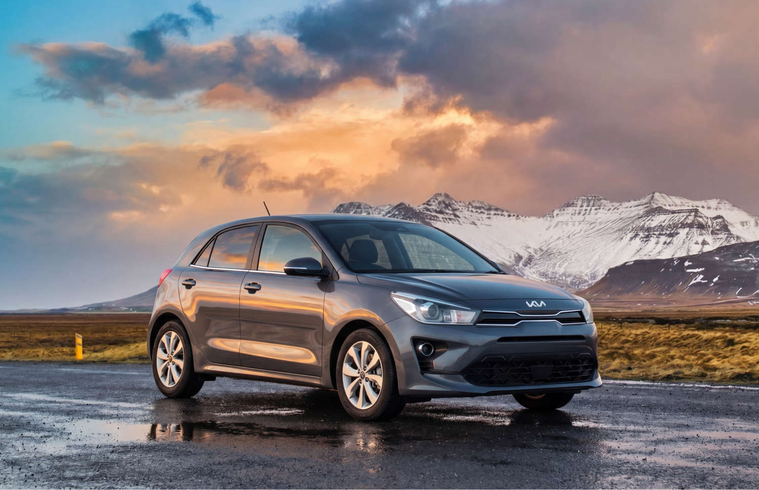Blue Kia Rio with manual transmission, GPS, reverse camera, and space for 5 passengers and 2 luggage, ideal for Iceland road trips.