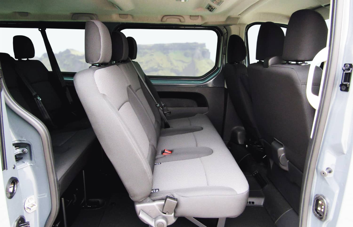 Roter Renault Trafic 9-Sitzer-Passagier-Van mit Schaltgetriebe, Sitzheizung, Bluetooth und USB-Ladegerät – ideal für Gruppenreisen in Island.