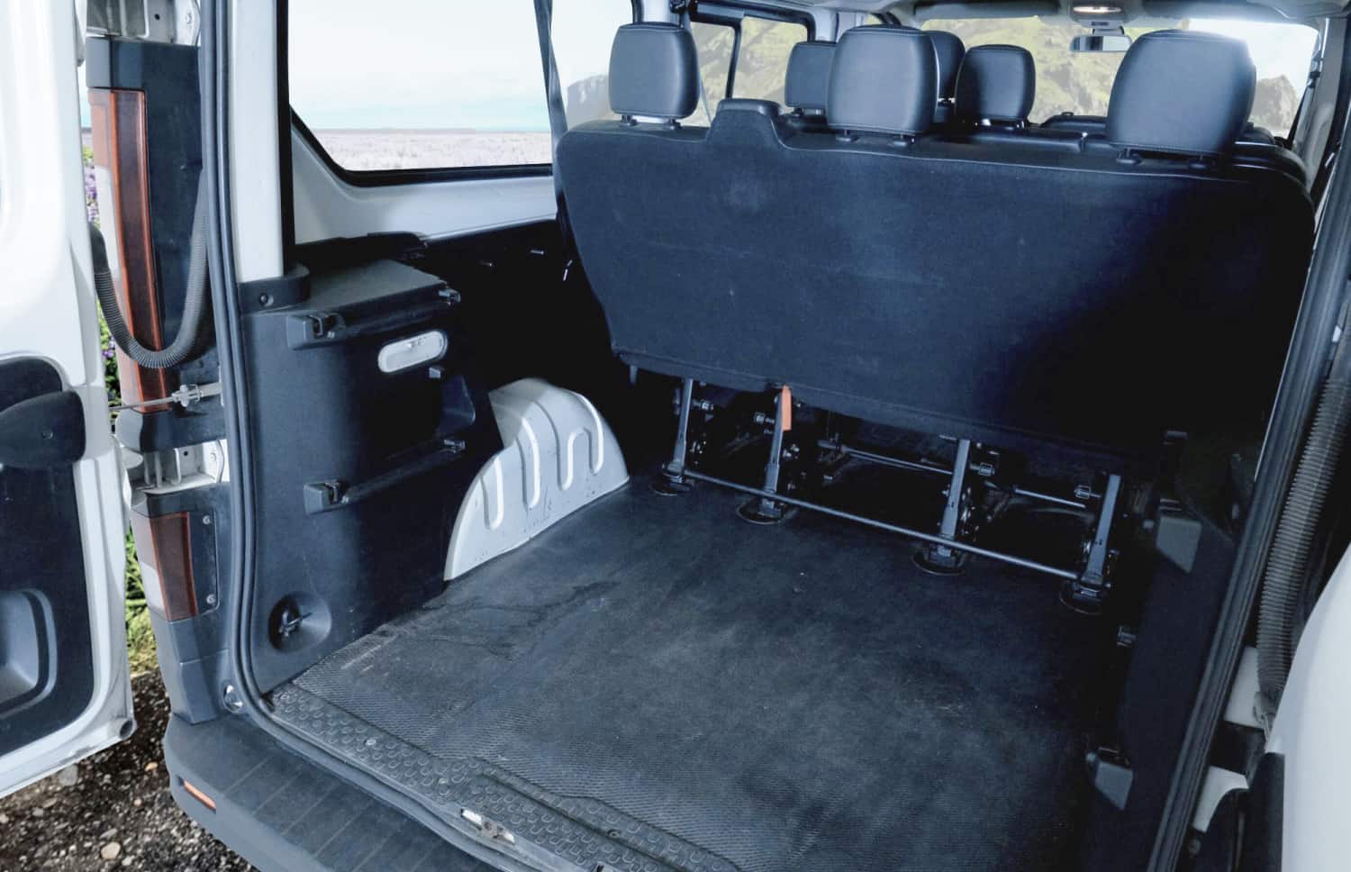 Roter Renault Trafic 9-Sitzer-Passagier-Van mit Schaltgetriebe, Sitzheizung, Bluetooth und USB-Ladegerät – ideal für Gruppenreisen in Island.