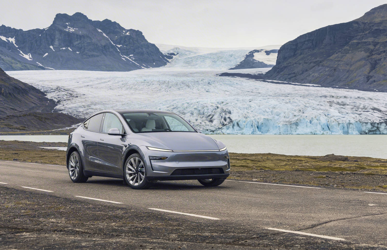 Blue Tesla Model Y electric SUV with automatic transmission, GPS, reverse camera, heated seats, and room for 5 passengers and 2 luggage in Iceland.
