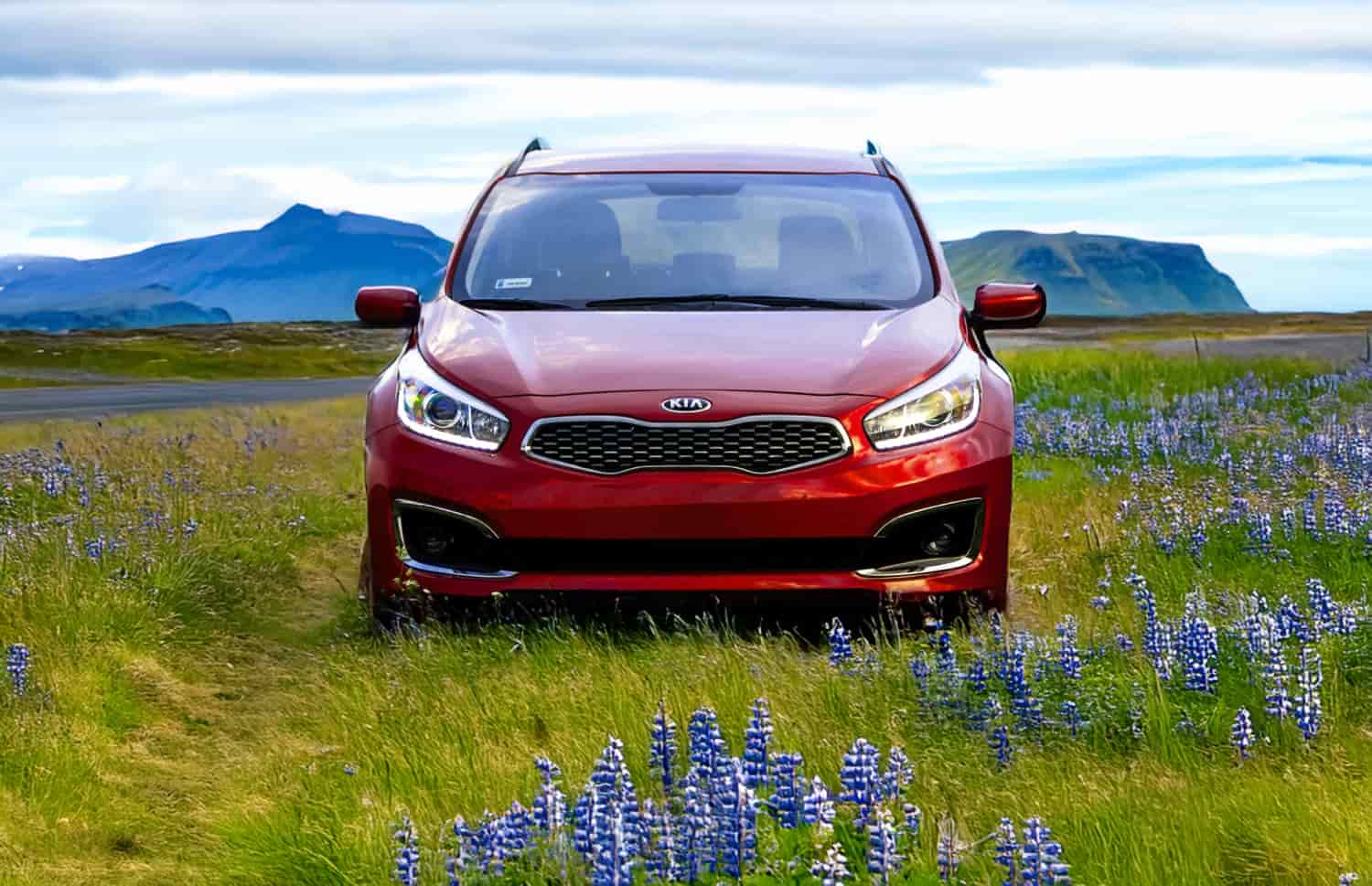 Kia Rio rouge d’occasion avec boîte manuelle, compacte 5 places avec espace pour 2 bagages, parfaite pour un voyage abordable en Islande.