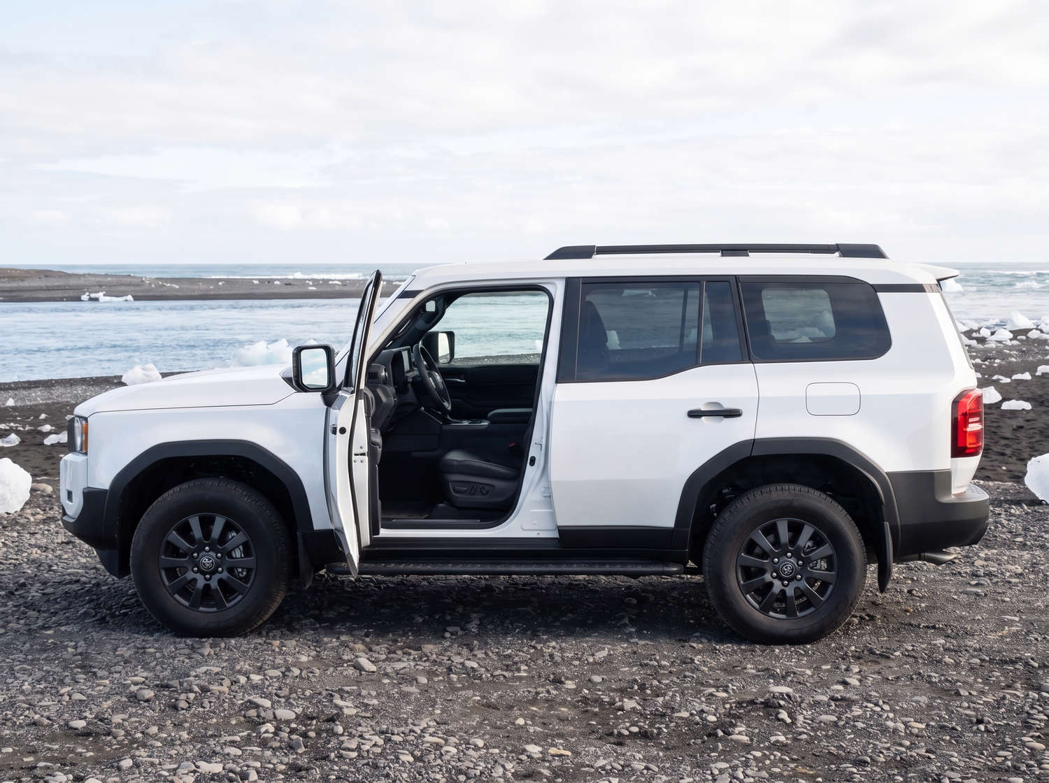 White Toyota Land Cruiser 250 4WD SUV with automatic transmission, 7 seats, USB charger, Bluetooth, and heated seats, perfect for Iceland off-road adventures.