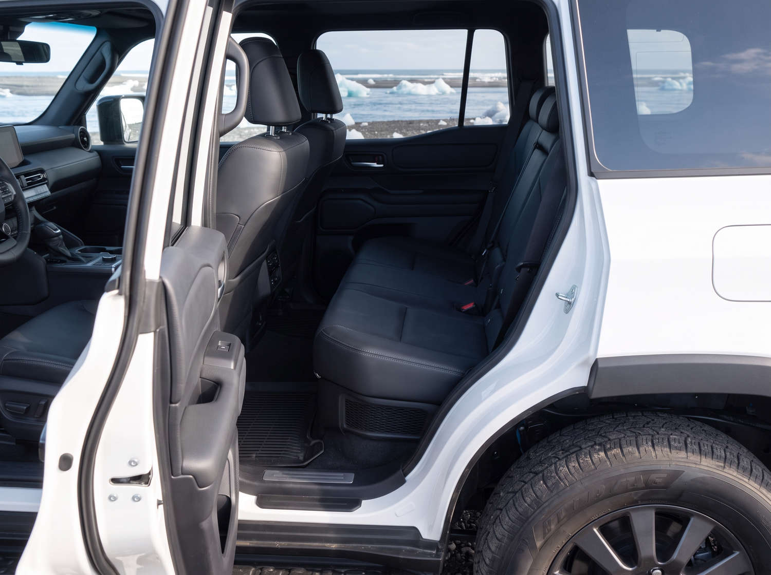 White Toyota Land Cruiser 250 4WD SUV with automatic transmission, 7 seats, USB charger, Bluetooth, and heated seats, perfect for Iceland off-road adventures.