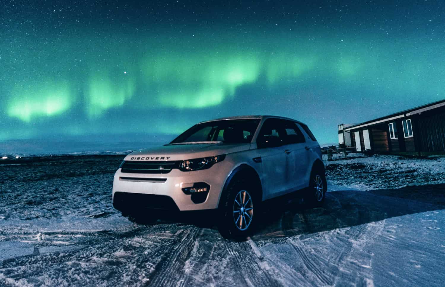 Land Rover Discovery Sport blanco, SUV 4x4 con transmisión automática, GPS, cámara de reversa y asientos calefactables; ideal para 5 pasajeros en Islandia.