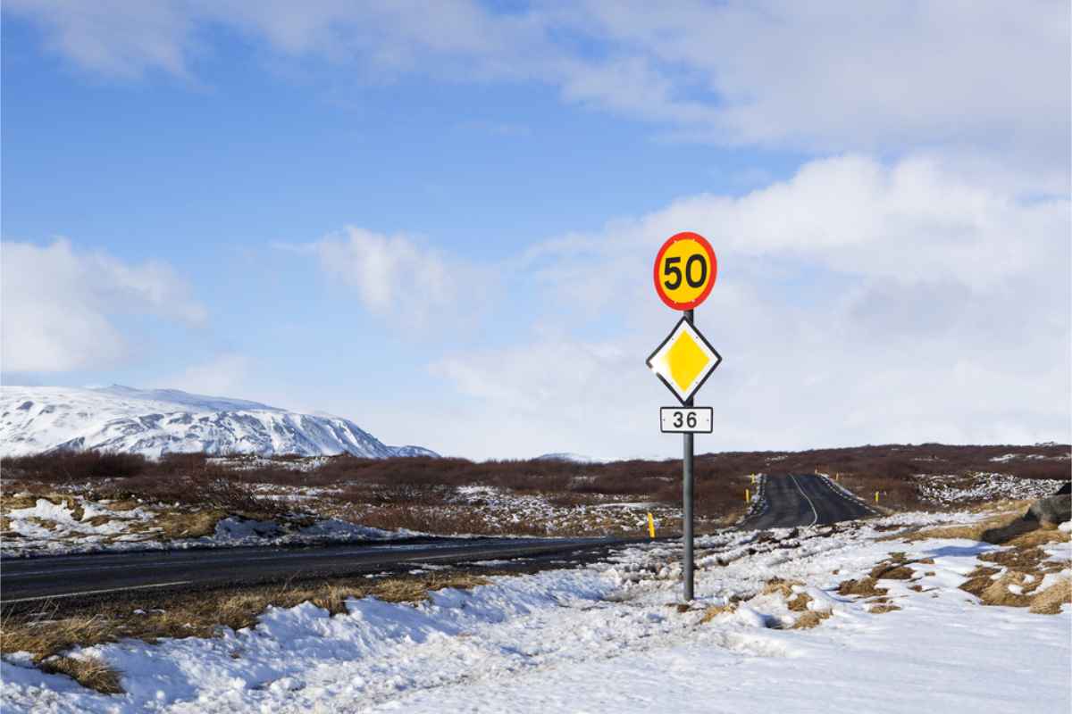 Tempolimit-Schild auf verschneiter Straße