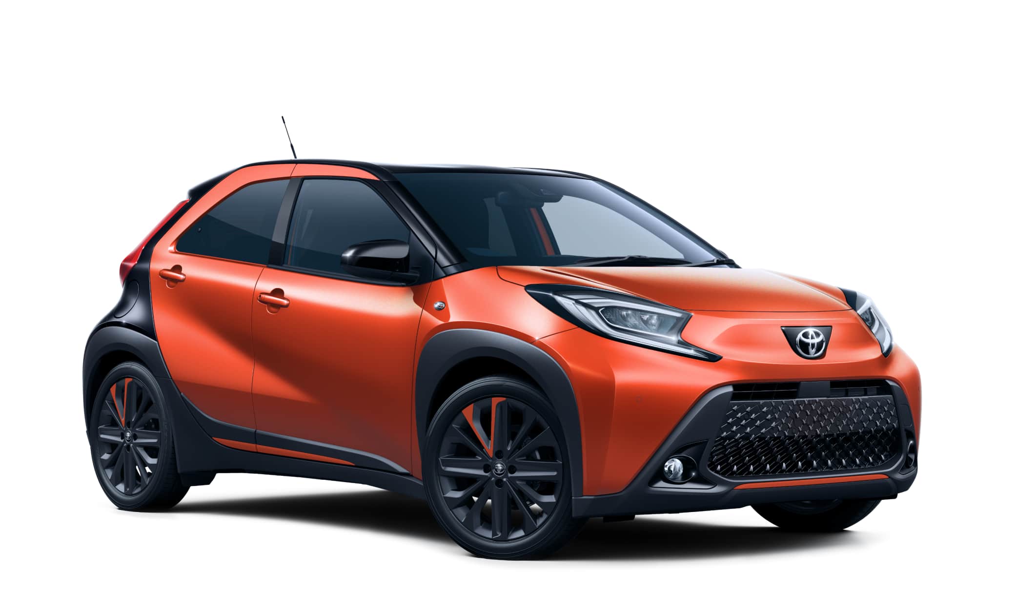 Leuchtend orangefarbener Toyota Aygo mit Automatikgetriebe, ideal für 4 Personen, kompakt und effizient für Fahrten in isländischen Städten.