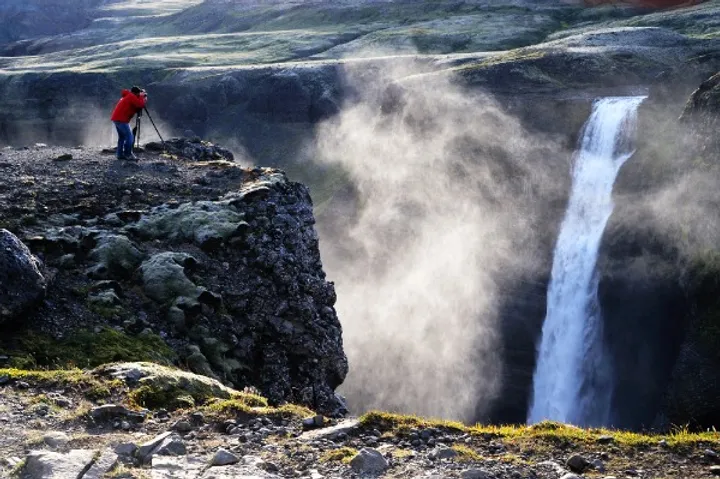 Turista fotografiando la cascada Haifoss - La hipnotizante cascada de las tierras altas de Islandia 