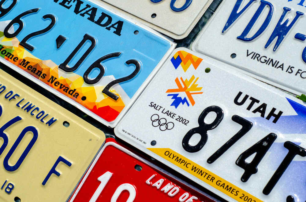 Un ensemble de plaques d’immatriculation colorées provenant de différents états des États-Unis, disposées côte à côte.