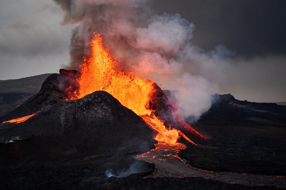 Éruption d'un volcan islandais avec émission de lave brûlante. Éruption volcanique massive avec des rivières de lave incandescente et une épaisse fumée s'élevant dans le ciel.