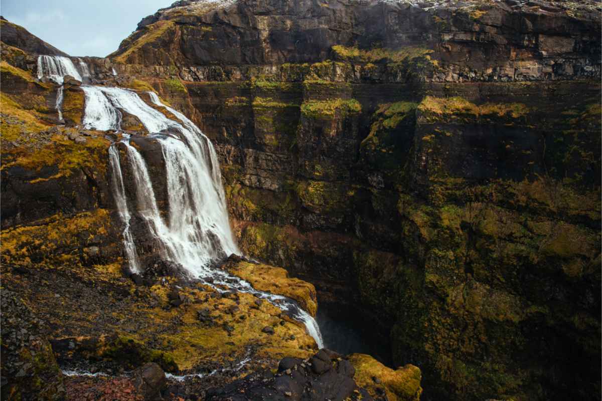 Vue spectaculaire de la randonnée menant à la cascade Glymur, un sentier pittoresque à travers vallées verdoyantes et rivières sinueuses.