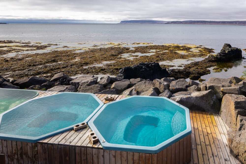 Bains chauds surplombant l'océan en Islande Trois bassins octogonaux remplis d'eau chaude avec vue sur l'océan Atlantique et un littoral rocheux.