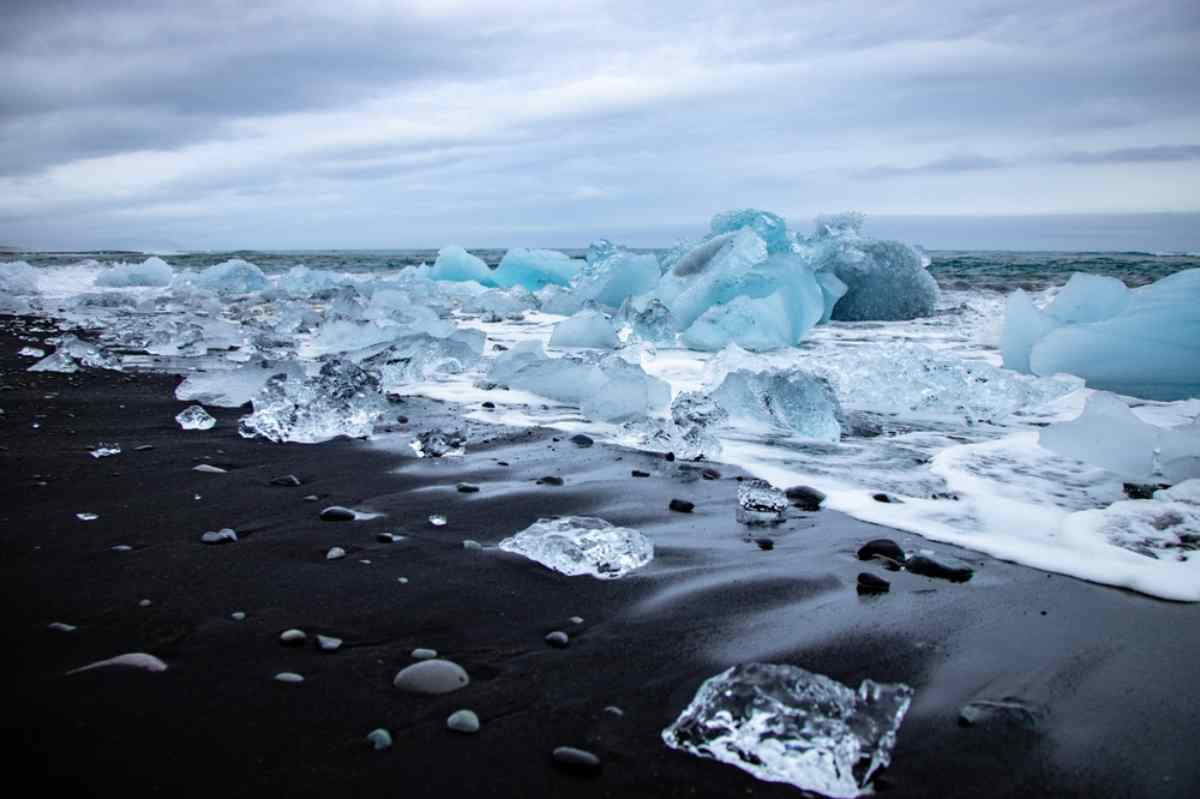 Détail en gros plan des rochers de la plage Diamant en Islande avec leur transparence particulière contrastant avec le sable noir.
